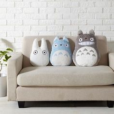 three stuffed animals sitting on top of a couch