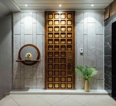 a large wooden door sitting next to a plant in front of a wall mounted clock