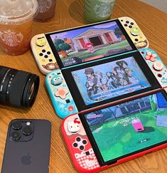 four nintendo wii game controllers sitting on top of a wooden table next to an iphone