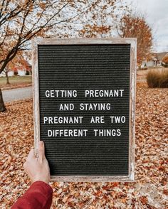 someone holding up a sign that says getting pregnant and staying pregnant are two different things