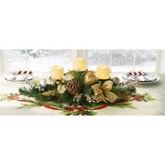 a christmas centerpiece with candles and pine cones