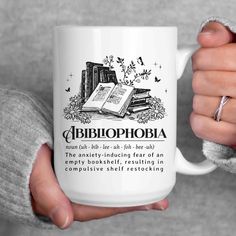 a person holding a white coffee mug with an open book on it and russian text