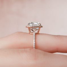 a woman's hand holding an engagement ring with a large diamond in the center