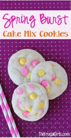 three cookies with pink and yellow sprinkles next to two drinking straws