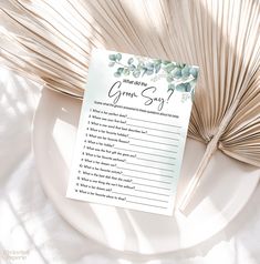 a white plate with a green song on it next to a palm frond fan