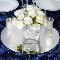 a table set with white roses and candles for an elegant dinner party or special occasion