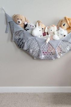 there are stuffed animals in a hammock hanging on the wall