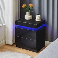 a black night stand with two flowers on it