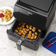 an open air fryer sitting next to a plate of food