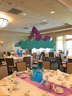 a dining room set up for a party with plates, cups and napkins on the table