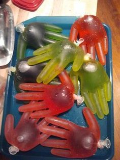 several plastic hand puppets are placed on a blue tray with spoons and utensils