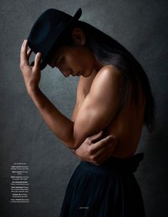 a shirtless man in a black hat and dress poses for a magazine cover shot