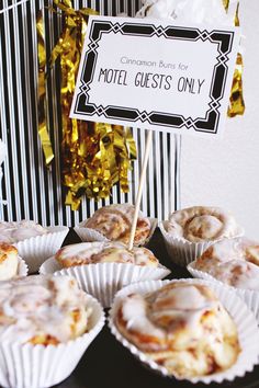 a table topped with cupcakes covered in icing next to a sign that says hotel guests only