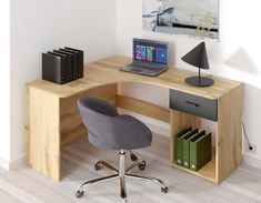 a computer desk with a laptop on top of it next to a chair and bookshelf