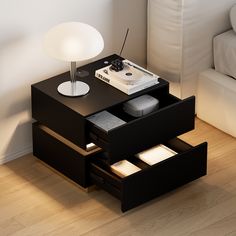 a night stand with two drawers and a light on it in a living room next to a couch