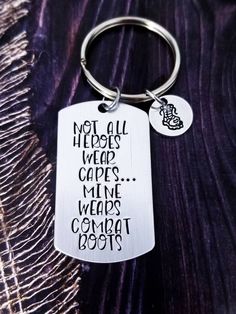 a metal keychain with the words not all heros wear capes