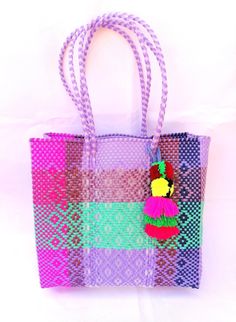 This woven bag is made of thick and resistant plastic. Large size. In Mexico it is used to make purchases and that's is called 'Market bag' either 'The grocery bag'. The measurement could vary from bag to bag, because they are handmade, but these bags have the following measures aproximately : wide 13 "(33cm)  high 12" - 11 1/4" (31cm-29cm) deep 5" - 4 1/2" (13cm-11.5cm) long handles 10" -9"  (25cm-22cm) This bag come with a tye dye multicolor pompom The colors could vary slightly from the pictu Multicolor Woven Beach Bag For Market, Multicolor Tote Beach Bag For Market, Colorful Handwoven Tote Bag, Fair Trade Tote Beach Bag For Shopping, Purple Handwoven Rectangular Bag, Rectangular Purple Handwoven Bag, Square Multicolor Handwoven Crochet Bag, Multicolor Woven Bags For Shopping, Multicolor Woven Shopping Bags