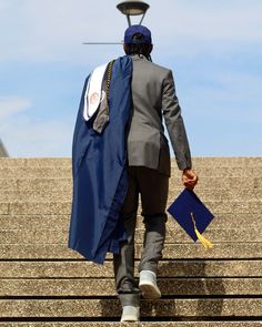 a man walking up some steps wearing a blue cape