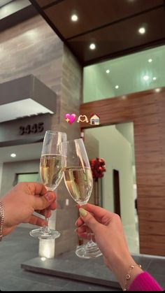 two people toasting with champagne in front of a building