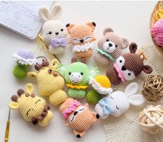 small crocheted stuffed animals sitting on top of a table next to knitting needles