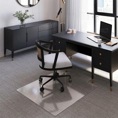 a desk with a chair and a laptop on it in front of a large window