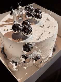 a white cake with silver mirror balls on it