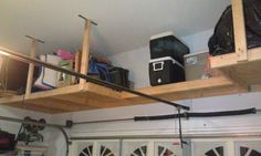 there is a shelf above the garage door with some equipment on it and bags hanging from the ceiling