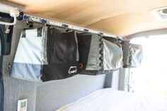 the back end of a camper with luggage hanging from it's side wall