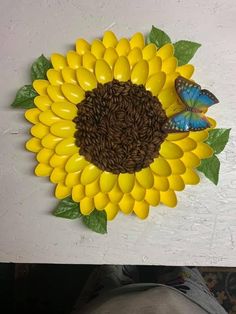 a yellow sunflower with green leaves and a blue butterfly on it's back