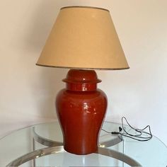 a red lamp sitting on top of a glass table