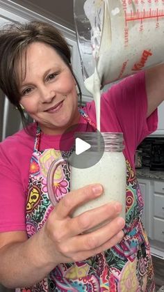 a woman pouring milk into a jar