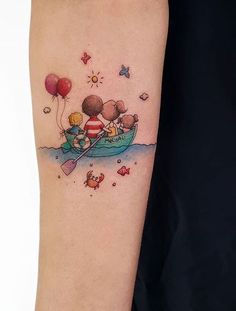 a woman's arm with a small tattoo of two people in a boat