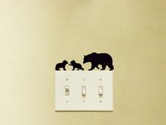 there is a bear and two cubs on the light switch