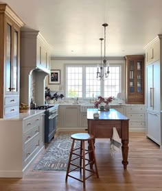 a large kitchen with an island in the middle and two stools next to it