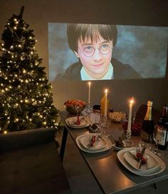 a christmas tree is in front of a projection screen with harry potter glasses on it