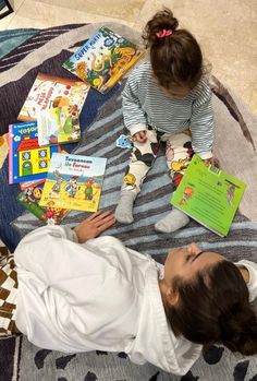 two children are sitting on the floor reading books