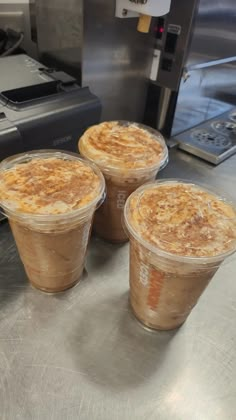 three plastic cups filled with food sitting on top of a counter