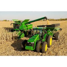 two green farm tractors in a field