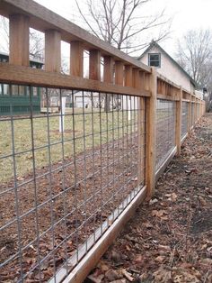 the fence is made of wood and has metal bars on each side, along with leaves