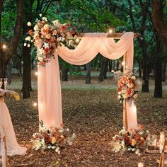 an outdoor wedding set up in the woods with flowers and candles on the altars