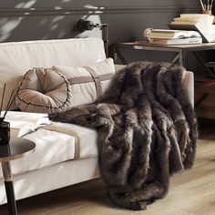 a living room filled with furniture and a fur rug on top of a wooden floor