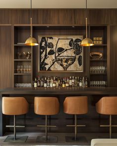 a bar with three stools in front of it and a painting on the wall