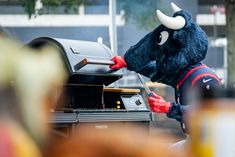 a person dressed as a bull grilling some food