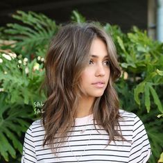 The Medium-Length Layered Hair Cut That's Stunning On Any Face Shape Long Layers With Chin Length Bangs, Choppy Layers For Fine Hair Mid Length, Layers For Long Hair Thick Hair, Long Shag Natural Wavy Hair, 2023 Hair Trends For Thick Hair, Popular 2023 Hairstyles, Long Bob With Bangs Oval Face, Curtain Bangs Over 40 Fine Hair, Medium Length Haircut Big Forehead