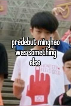 a young boy holding up a sign with the words, predebut minghao was something else