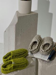 there is a pair of knitted slippers next to a book