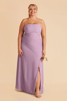 a woman in a purple dress smiling and posing for the camera with her hands on her hips