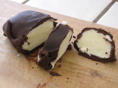 a chocolate covered dessert sitting on top of a wooden cutting board