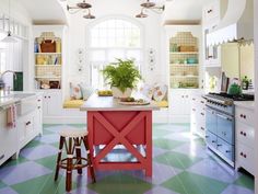 a kitchen with an island and potted plant in the center, surrounded by white cabinets