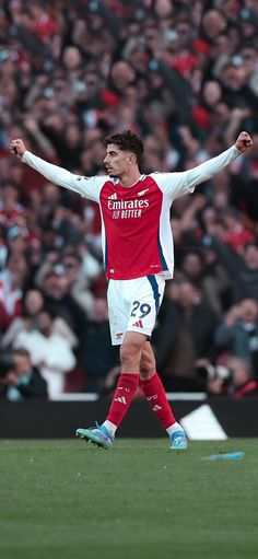 the soccer player is celebrating his team's win in front of an enormous crowd